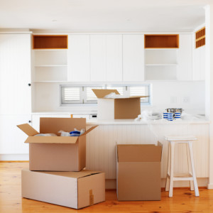 Open cardboard boxes kept in an empty kitchen
