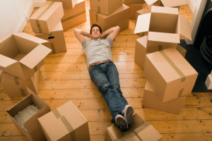 Man relaxing with moving boxes